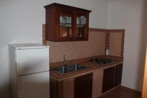 a kitchen with a white refrigerator and a sink at Residence Hotel Torresilvana in Vieste