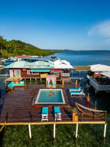 a wooden deck with a swimming pool and chairs at Coral Wing Casitas in Bastimentos