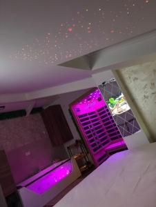 an empty room with purple lights on the ceiling at SpaNish SKY 1 sauna&jacuzzi in Niš
