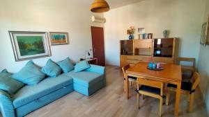 a living room with a blue couch and a table at BILOCALE IN PIAZZA A NUMANA VISTA MARE BELLISSIMA - cod 485 in Numana +14 photos