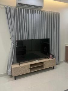 a large flat screen tv sitting in front of a window at TwentyFour Seven Residence in Tabuk