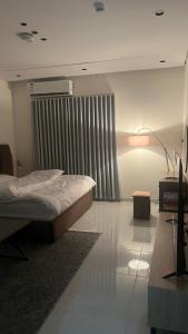 a bedroom with a bed and a table and a lamp at TwentyFour Seven Residence in Tabuk