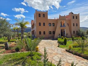 an exterior view of a large house with a stone driveway at Kasbah Ntifa in Ouzoud