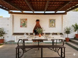 a wooden table with wine glasses on a patio at Villa Mabrouka in Raʼs al Jabal