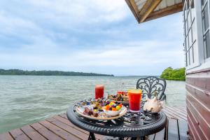 a table with a plate of food and drinks on a dock at Coral Wing Casitas in Bastimentos