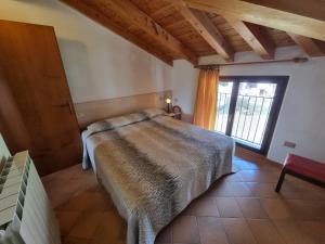 a bedroom with a bed and a large window at Casa Enrico in Pieve Di Ledro