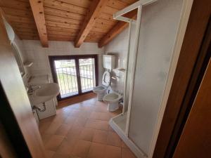 a bathroom with two toilets and two sinks and a window at Casa Enrico in Pieve Di Ledro +75 photos