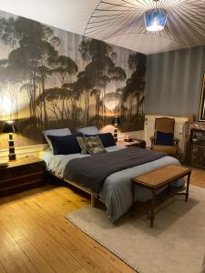 a bedroom with a bed with a painting on the wall at La Romanee d Or in Marchampt