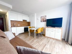 a living room with a table and a large screen tv at playa honda sky view in Playa de las Americas