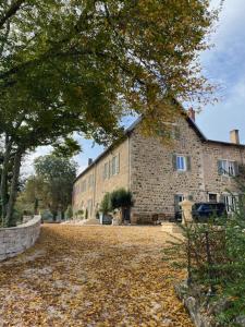 a large brick building with a car parked in front of it at La Romanee d Or in Marchampt