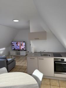 a kitchen and living room with a couch and a tv at Ankerplatz Drakenburgi in Drakenburg