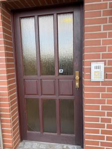a brown door with glass windows on a brick building at Ankerplatz Drakenburgi in Drakenburg