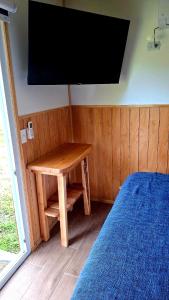 a room with a table and a television on a wall at Cabaña Los Carpinteros in Cochrane