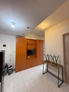 a living room with a table and a tv at Modern 2BR Apartment With Fast WiFi in Rawalumpang