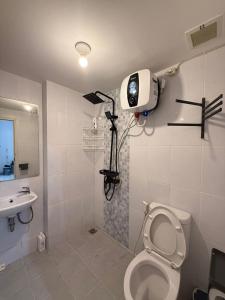 a bathroom with a toilet and a camera on the wall at Modern 2BR Apartment With Fast WiFi in Rawalumpang