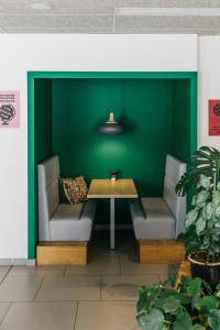 a table and chairs in a room with a green wall at The Social Hub Paris La Défense in Puteaux