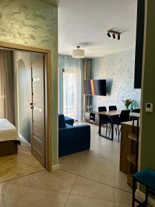 a living room with a blue couch and a dining room at Twoja Przystań SŁAWA- Apartament przy plaży in Sława