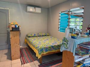 a small bedroom with a bed and a table at Le Petit Coin de EDEN in Parea
