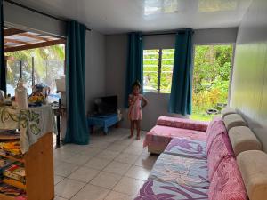 a little girl standing in a living room at Le Petit Coin de EDEN in Parea