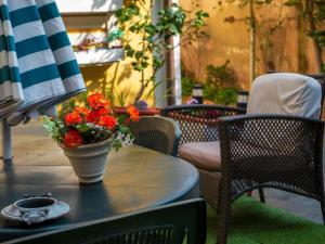 a table with a vase with red flowers on it at Apartment Su Cramu in Villacidro