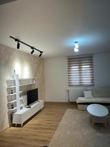 a living room with a couch and a tv and a table at Stan na dan Stanojević in Bratunac
