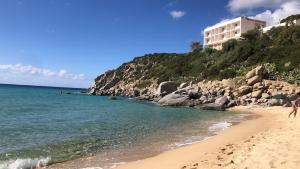 a beach with a building on a hill next to the ocean at Apartment Su Cramu in Villacidro