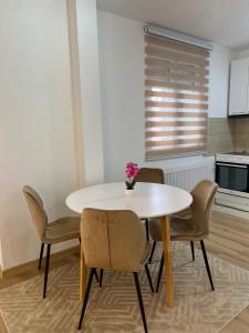a white table and chairs in a kitchen with a window at Stan na dan Stanojević in Bratunac