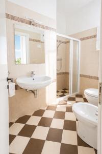 a bathroom with two sinks and a toilet and a shower at Hotel Damma's, Dipendenza Zamagna in Cesenatico +20 photos