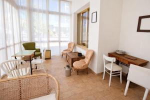 a living room with chairs and a table and a desk at Hotel Damma's, Dipendenza Zamagna in Cesenatico