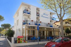 a red car parked in front of a building at Hotel Damma's, Dipendenza Zamagna in Cesenatico