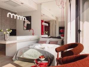 a bedroom with a bed and a red chair at Scarlet Jacuzzi Suit by Sofija in Warsaw