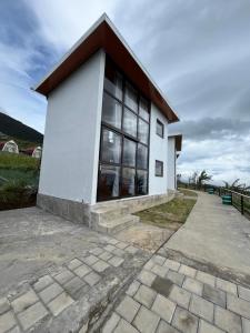a white building with a large window at Krincing Hills Cabin in Kalijoso