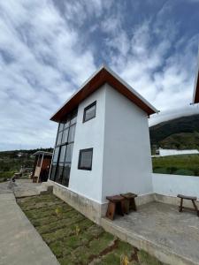 a small white building with a bench in front of it at Krincing Hills Cabin in Kalijoso