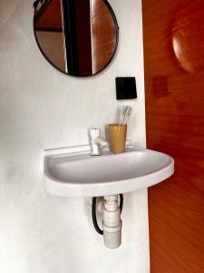 a white sink in a bathroom with a mirror at Krincing Hills Cabin in Kalijoso