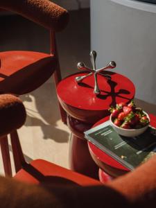 a plate with a bowl of fruit on a table at Scarlet Jacuzzi Suit by Sofija in Warsaw