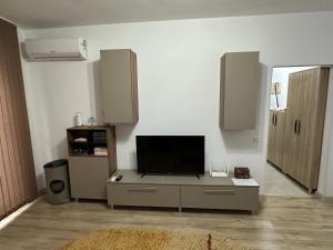 a living room with a flat screen tv on a cabinet at Astra Residence Ultracentral in Ploieşti