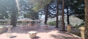 a patio with tables and chairs and umbrellas at Villa Chamoun in Al Wādī