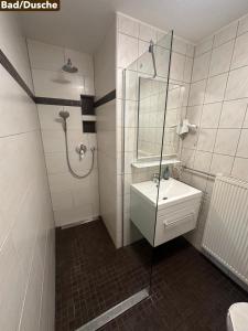 a bathroom with a shower and a sink and a mirror at Ferienwohnung Weiss in Rust +4 photos