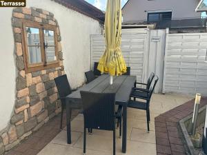 a table and chairs with a yellow umbrella on a patio at Ferienwohnung Weiss in Rust