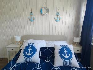 a bedroom with a bed with blue and white pillows at Gryfhaus - Pokój Kapitański, 19m2, blisko plaży, parking, wysoka ocena 9,5, 2-4 osoby in Międzyzdroje
