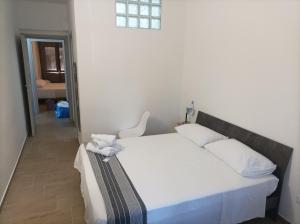 a bedroom with a white bed with a chair at Brezza Marina in Cirella