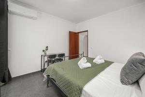 a bedroom with a bed with towels on it at Apartamento 3 Nações in Alvor