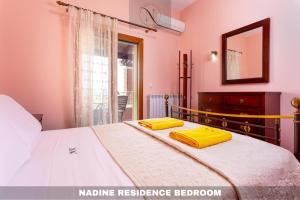 a bedroom with a bed with yellow pillows on it at Epavlis Nadine Corfu in Corfu +90 photos