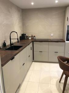 a kitchen with white cabinets and a sink at harbourways in Looe
