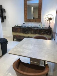a table with chairs and a mirror in a room at harbourways in Looe