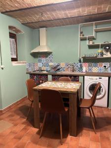 a kitchen with a table and chairs and a washing machine at Civico 15 in Antrosano