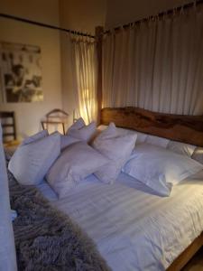 a large bed with white sheets and pillows at Agriturismo La Pina in Tarzo