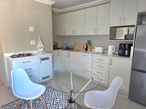 a kitchen with two chairs and a glass table at Miskin Place Unit 3 in Pennington