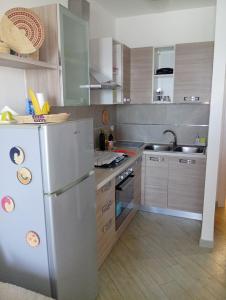 a kitchen with a stainless steel refrigerator and cabinets at Appartamento Belvedere in Castelsardo