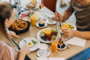a group of people sitting at a table eating breakfast at BERGlässig Hotel - Halbpension Plus inkl Getränke in Bodenmais